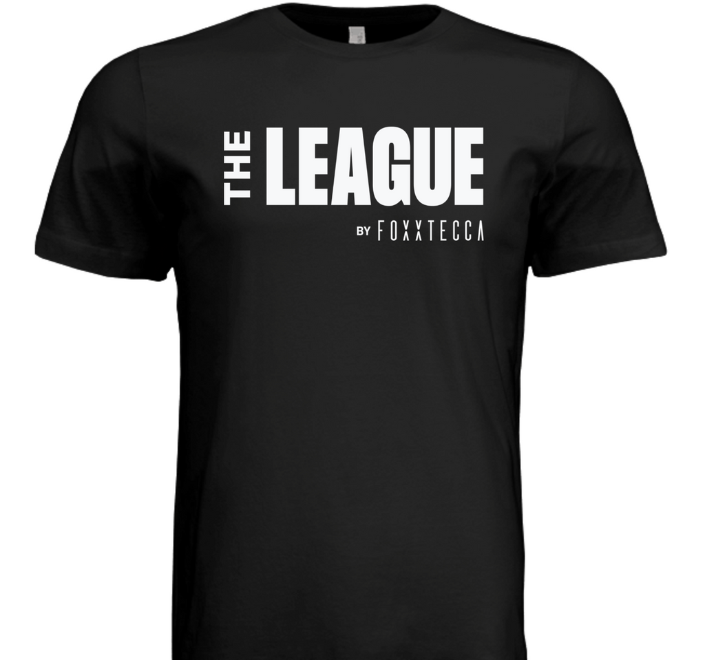 Front view of black t-shirt featuring bold white text “THE LEAGUE” stacked above the Foxxtecca logo, centered across the chest.